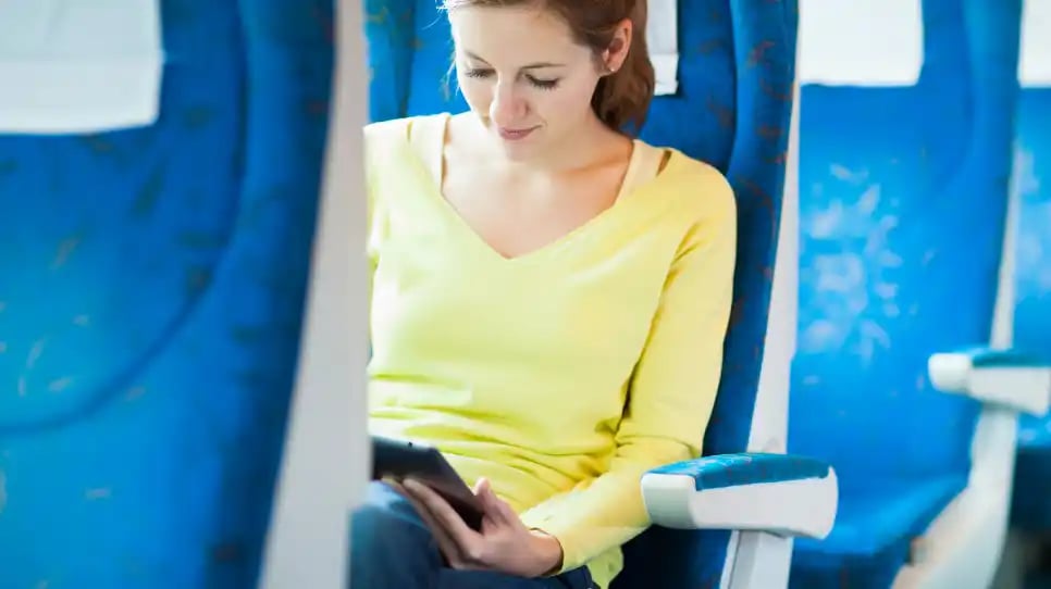 ragazza in treno intenta a studiare e lavorare