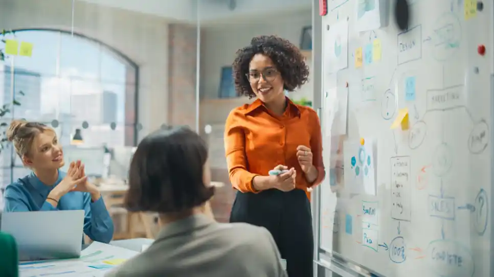 ragazza che parla davanti a una lavagna con post it che vuole diventare retail manager